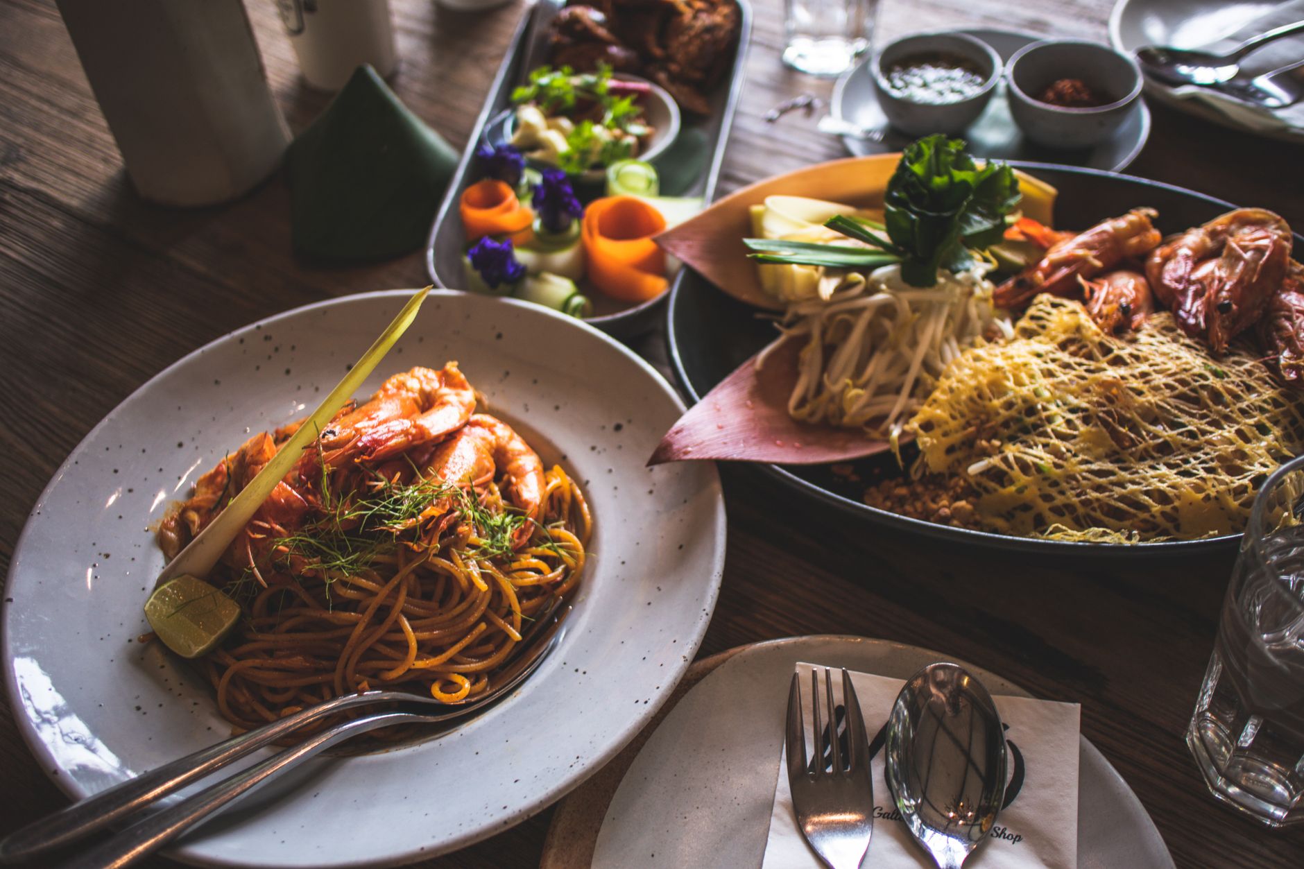 A plated Thai seafood dish with fresh vegetables, arranged on a wooden table