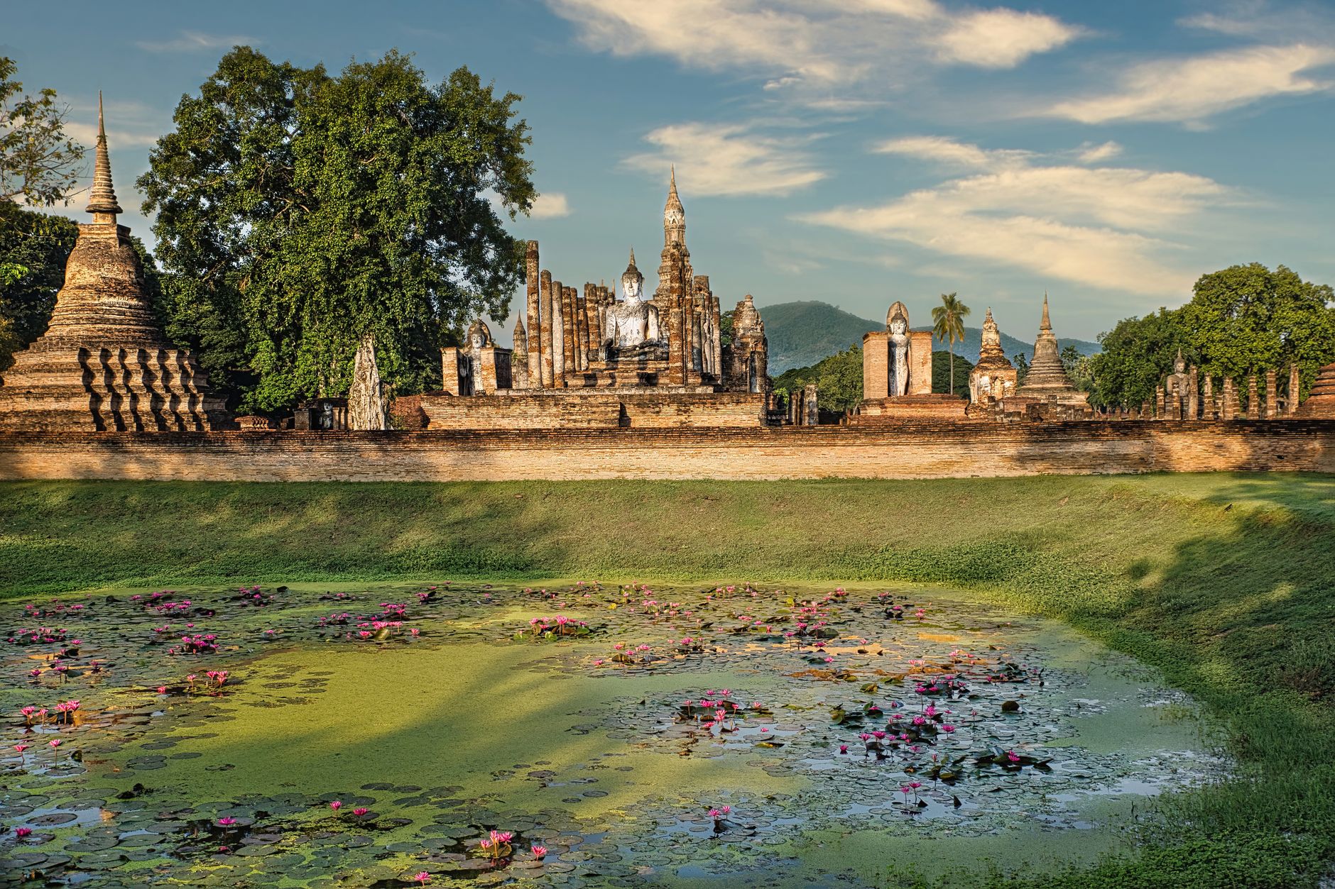 Ancient temple ruins reflected in a lotus pond at Sukhothai Historical Park, Thailand