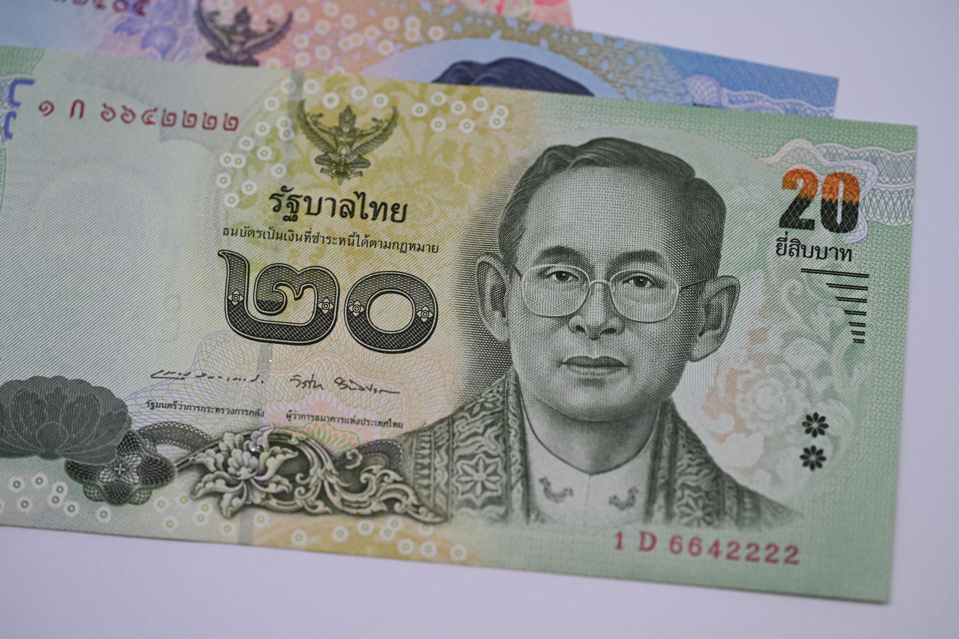 Thai baht notes laid out beside a travel map while planning a Thailand trip