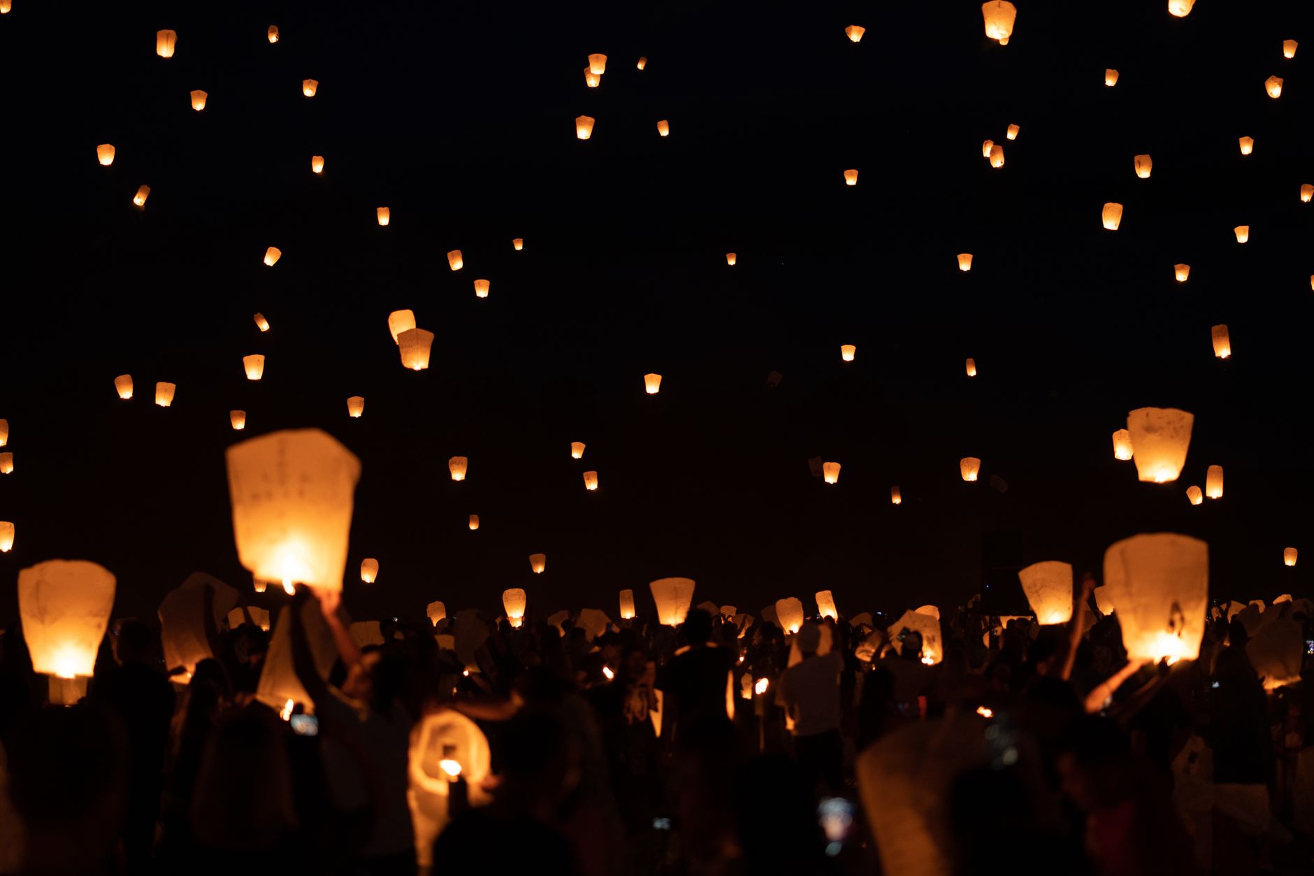 Sky lanterns rising into the night sky during a lantern release